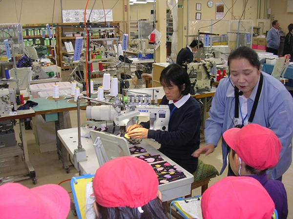 水着の縫製を実演し説明